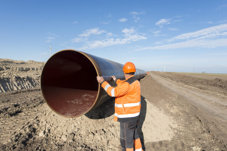 pipeline workers measuring tube length for construction of gas and oil pipes.